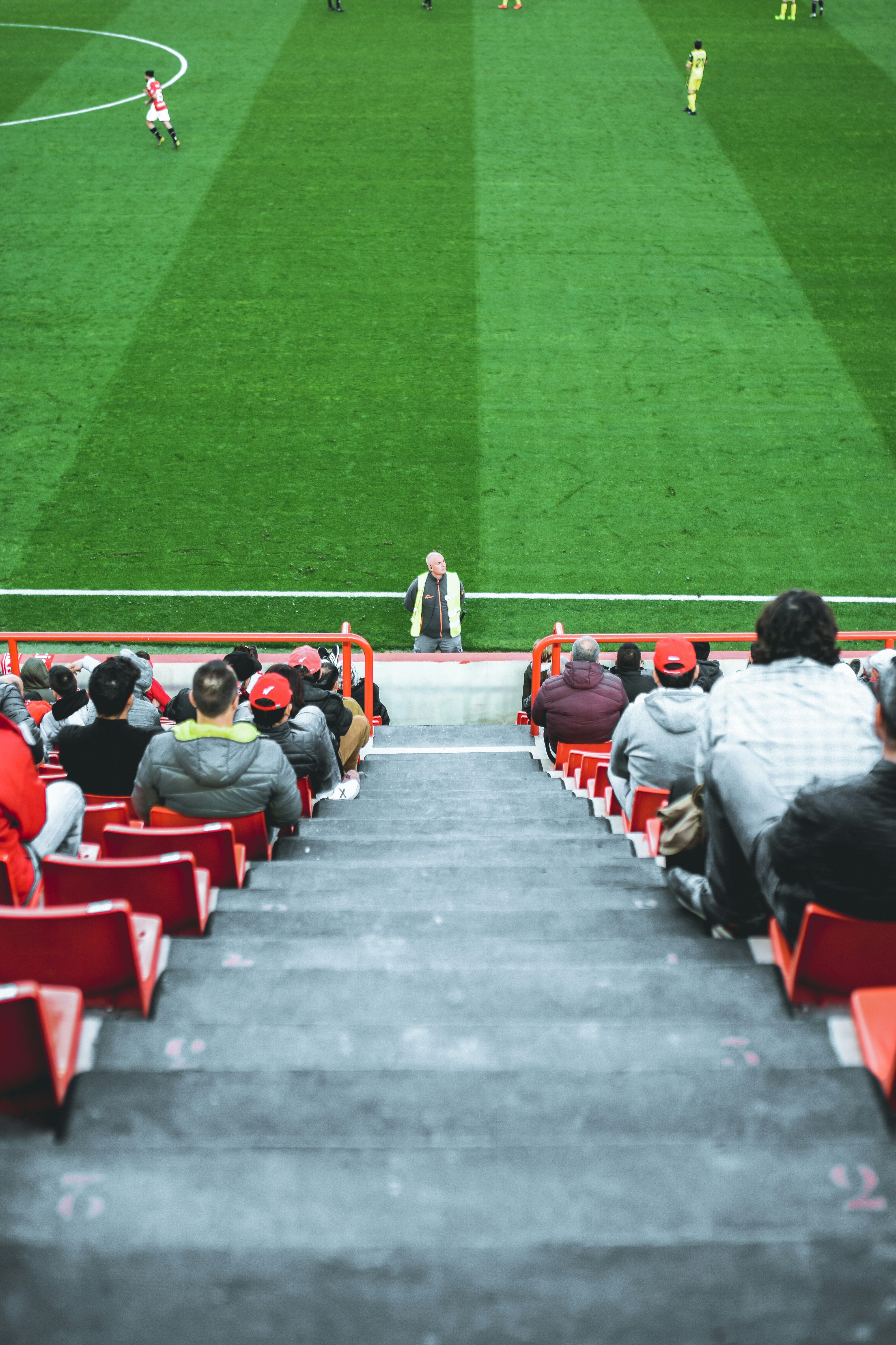 people sitting on arena bench photo Free Building Image on Unsplash