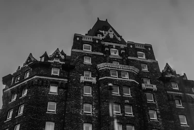Black and white illustration of a classic Belgian townhouse with intricate architectural details.