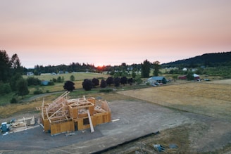 An experienced builder carefully inspecting a custom home under construction at sunset.