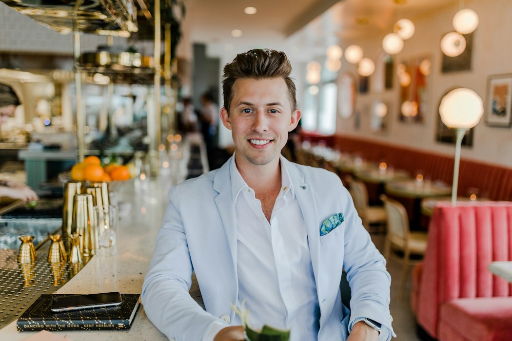 Host in a white blazer at a restaurant bar — restaurant billing software