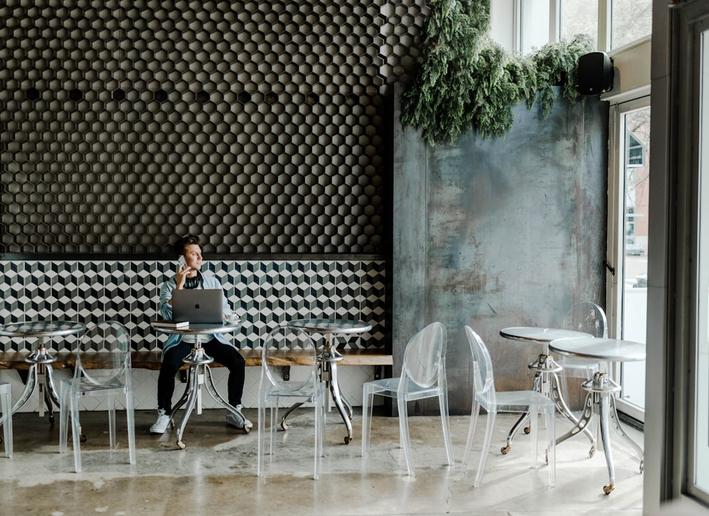 person sitting while using Macbook inside the building