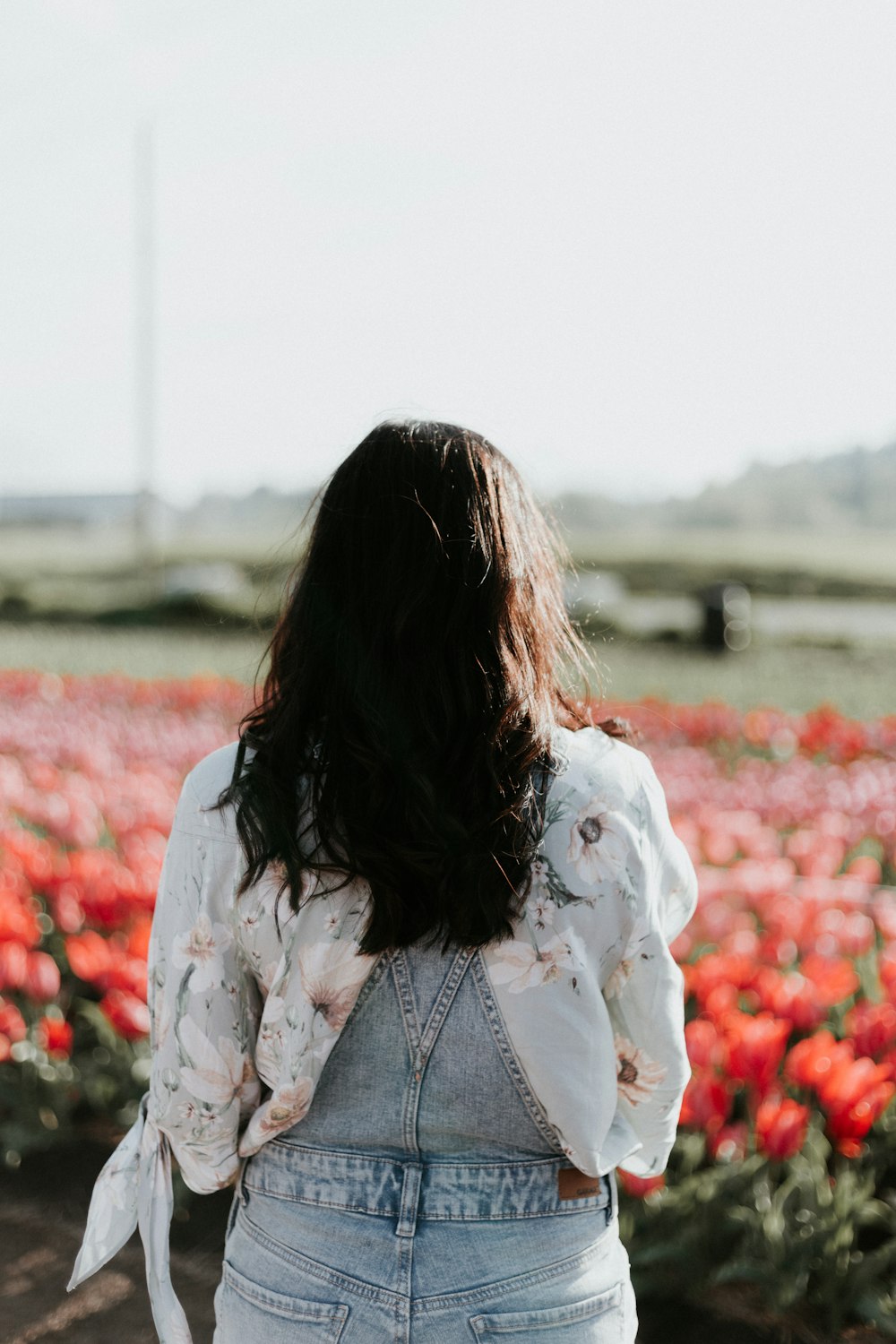 庭の花の前で白いシャツを着た女性