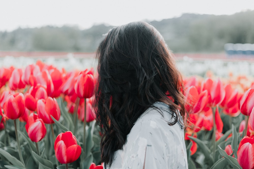 Mujer de pie en el campo de flores