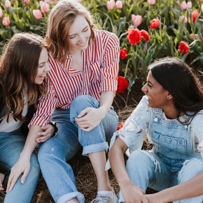 three woman sitting near the flower