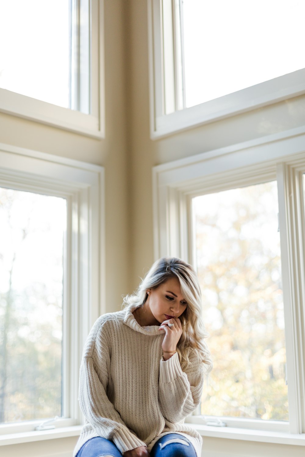 a woman is sitting on a window sill