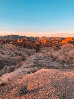 rock and hills under blue sky at daytime
