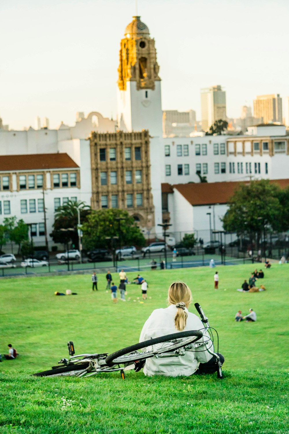 woman sitting beside black bicycle during daytime