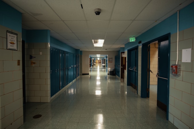 An empty school hallway lined with classroom doors, the setting where Nevada teacher licensing cases play out