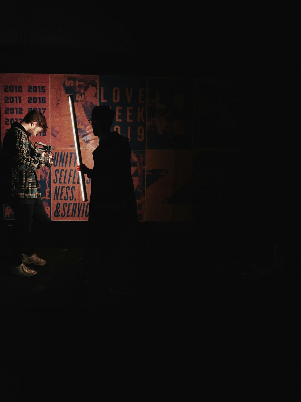 a man standing next to a woman in a dark room