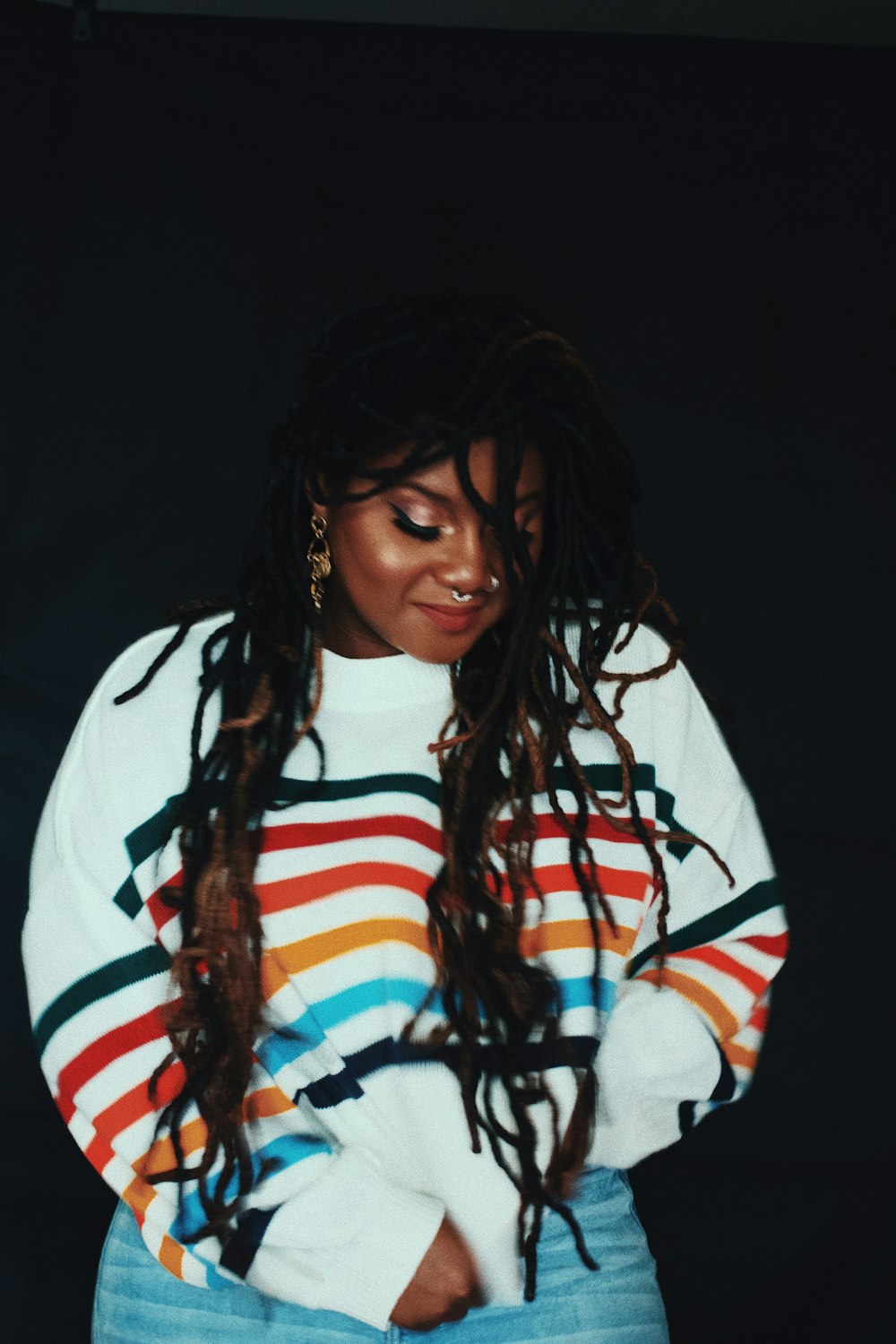 woman wearing white, black, red, and blue stripe sweater