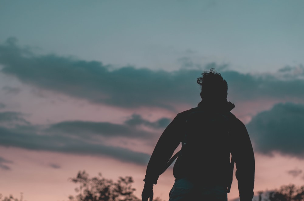 a silhouette of a man holding a frisbee