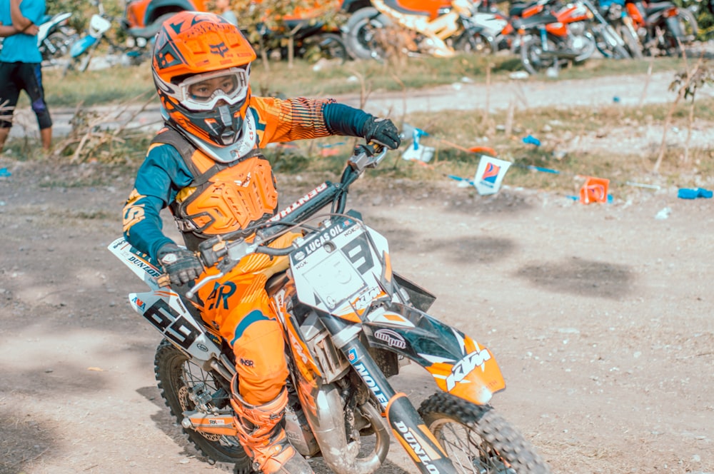 person wearing orange gear riding dirt bike