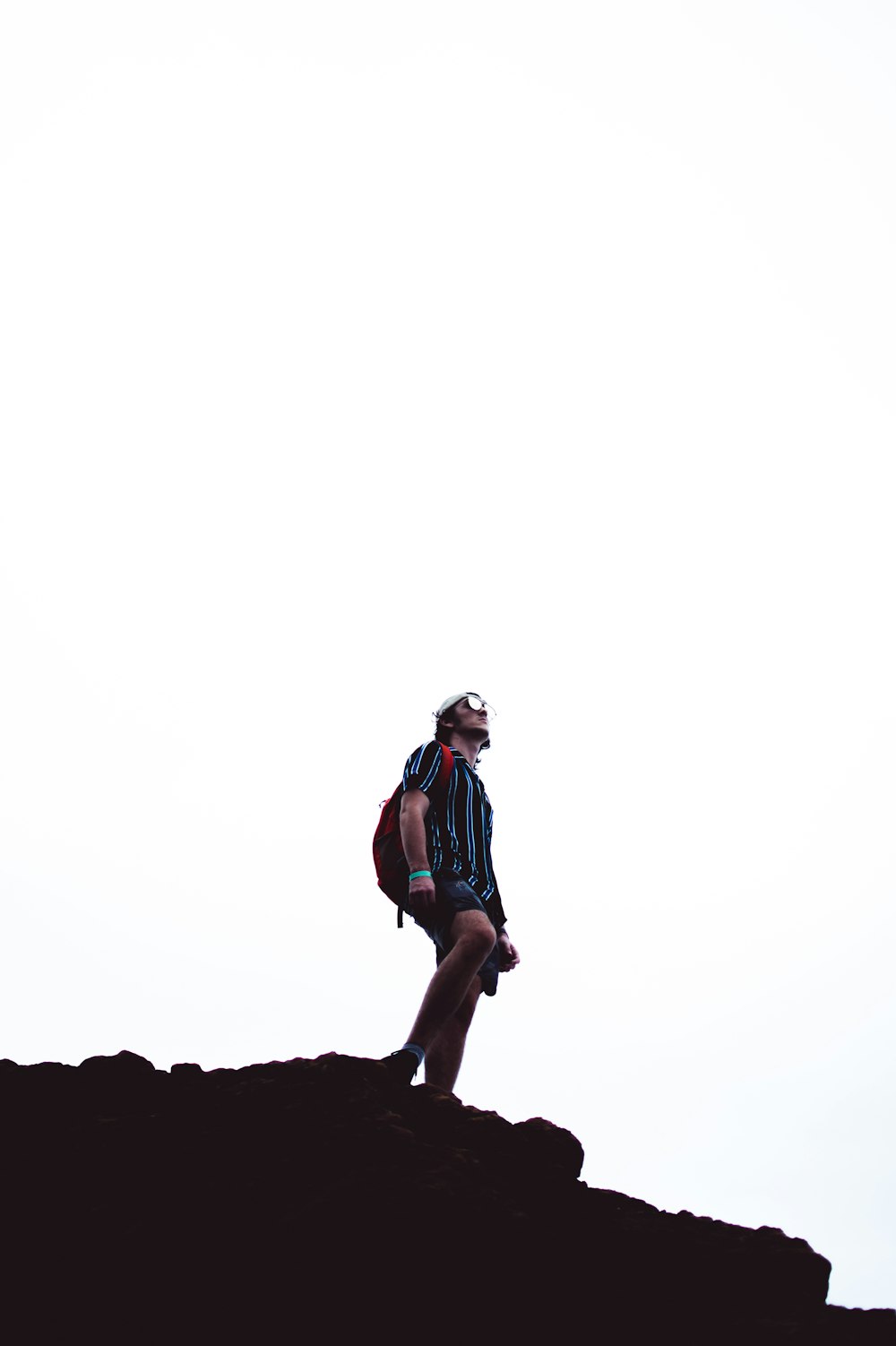 man standing on hill looking up