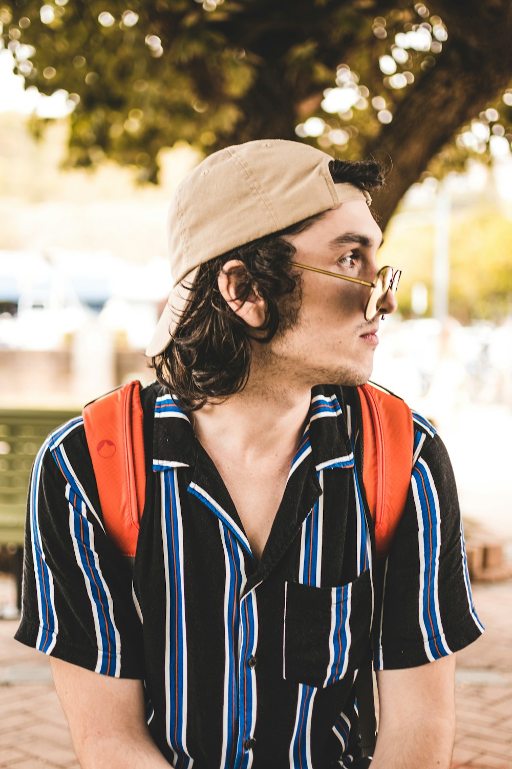 man wearing black and blue striped collared shirt looking at his left