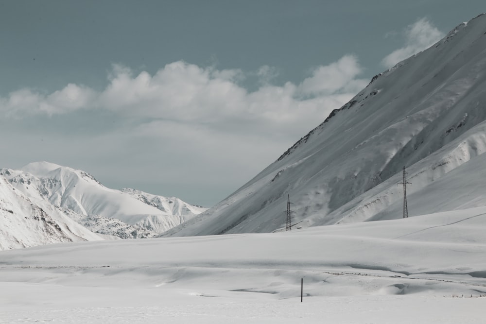 transmission tower on snow field during daytime