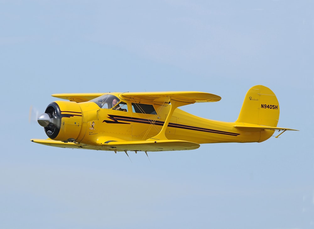 Fotografía de enfoque selectivo de biplano amarillo en el aire durante el día