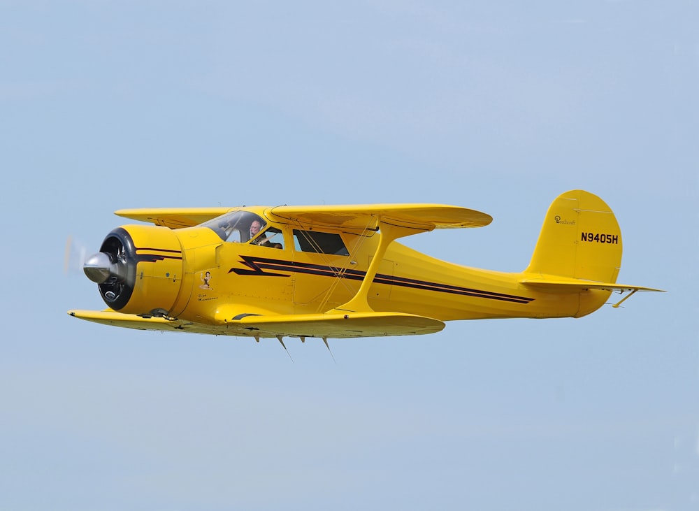 fotografia de foco seletivo de biplano amarelo no ar durante o dia