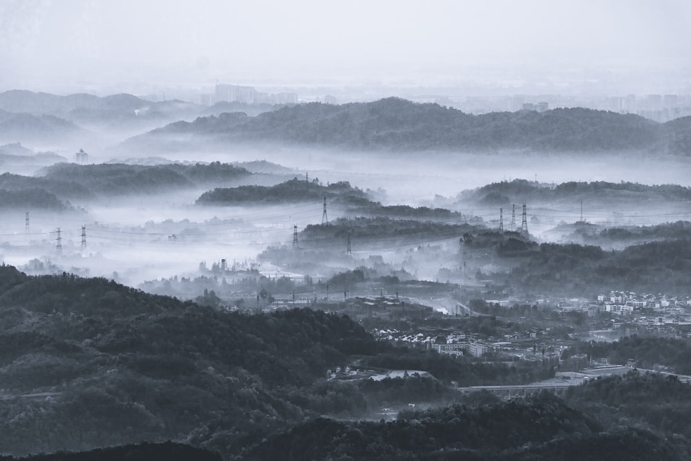 Foto en escala de grises de una montaña con niebla