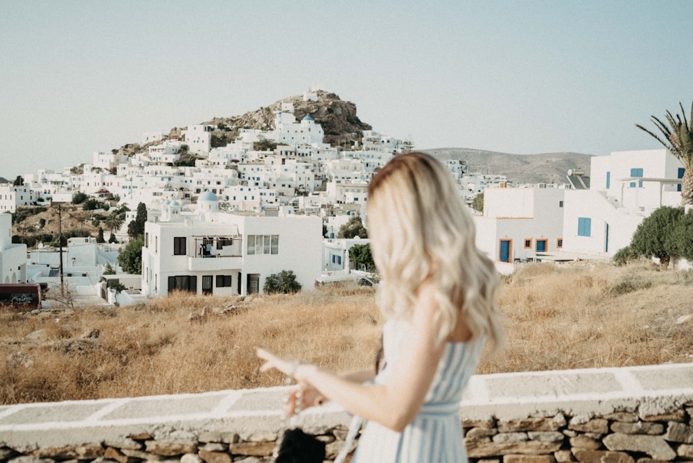 shallow focus photo of woman in white and blue striped sleeveless dress