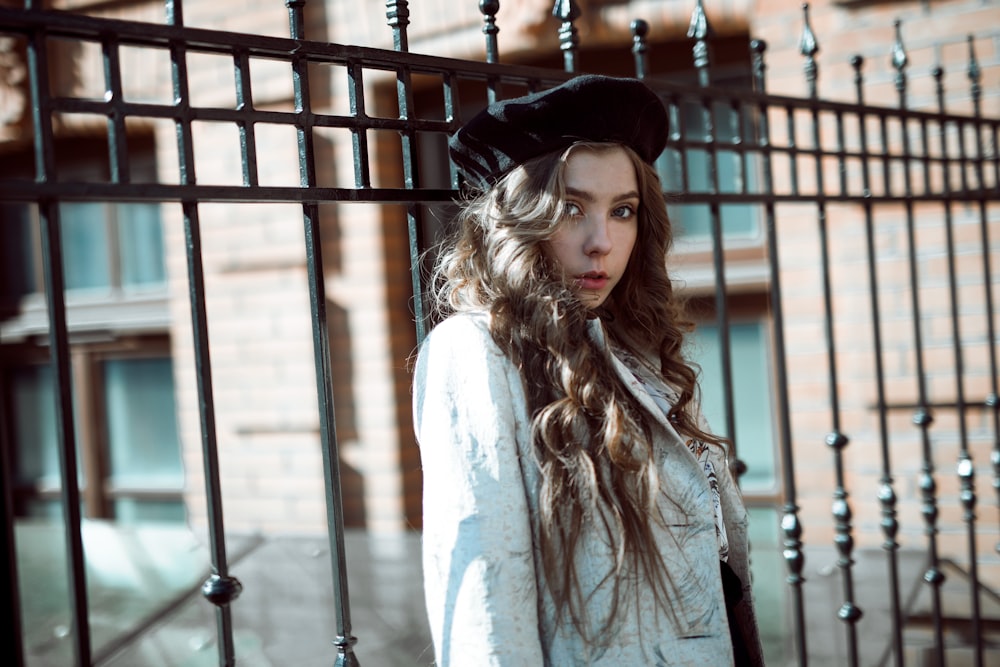 woman standing beside fence