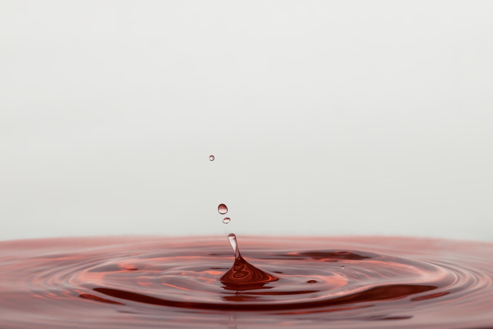 a drop of water falling into a brown liquid
