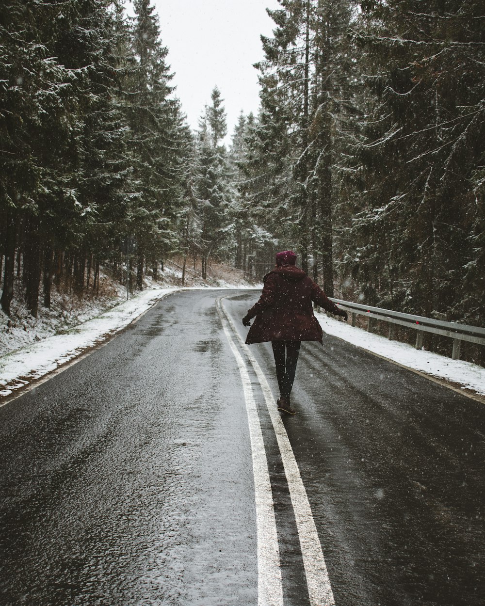 person walking on the street surrounded with trees