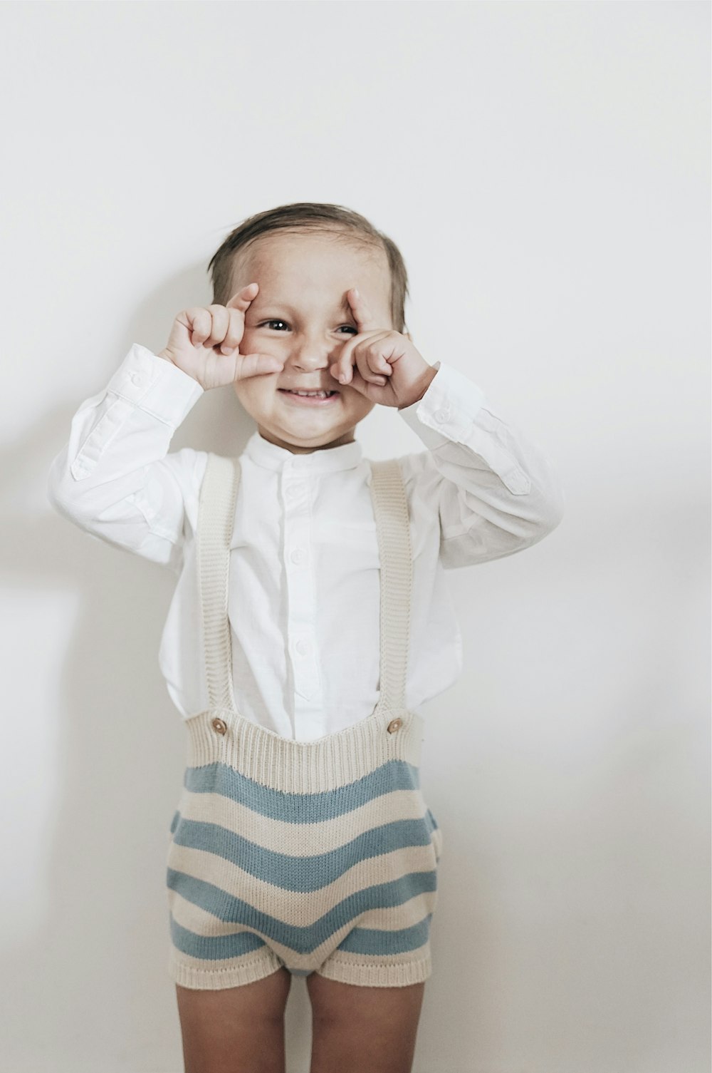 boy standing in front of white painted wall