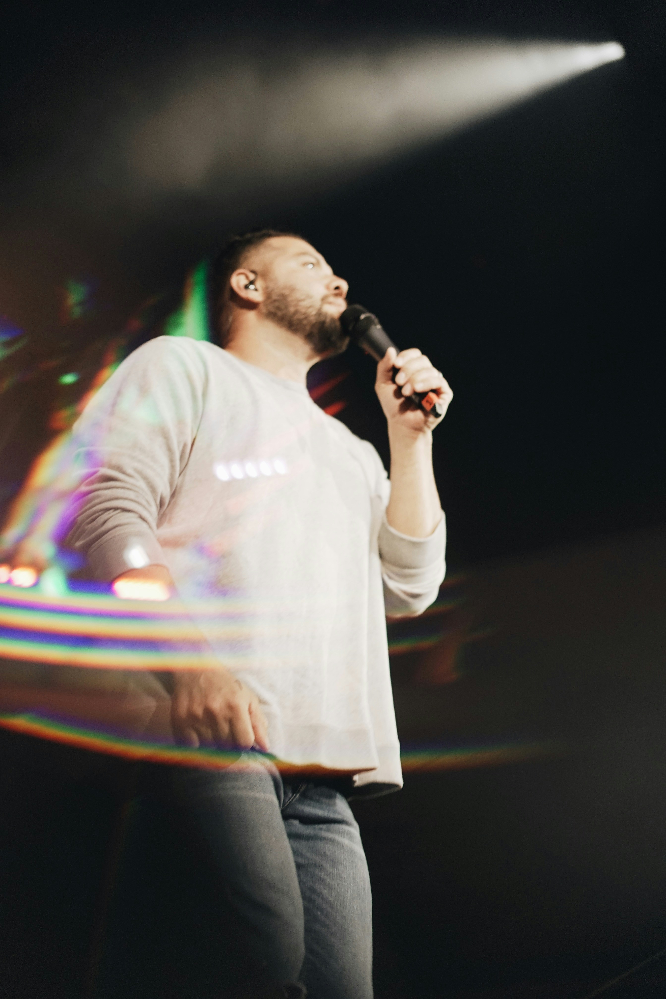 man wearing gray shirt holding microphone