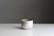 Minimalist product photo of a handmade ceramic mug on a clean white surface.
