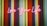 Neon pink cursive lettering spells out 'Love Your Life' against a vibrant striped background, featuring alternating colors of orange, red, green, blue, and purple.