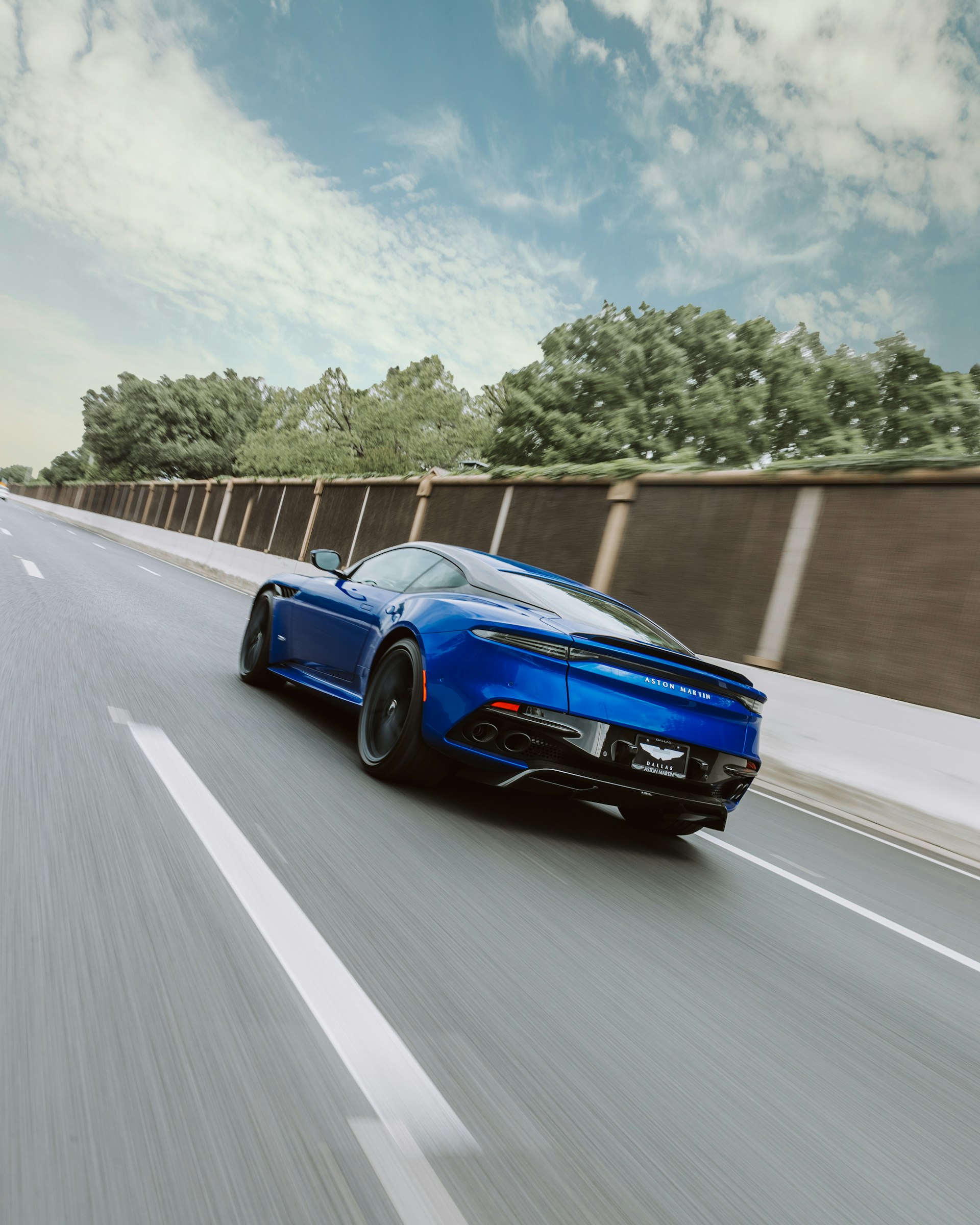 Blauwe coupé op een betonnen weg