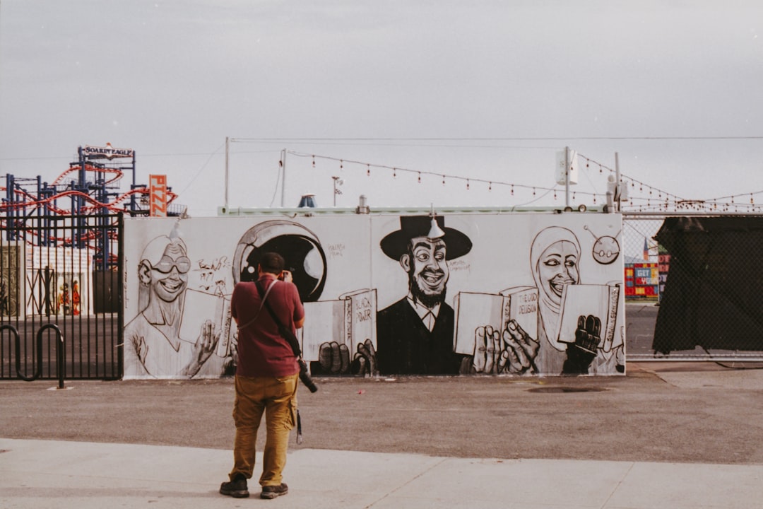 man standing beside graffiti wall during daytime