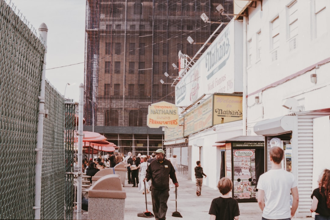 man in black shirt and pants holding sweep near boy walking