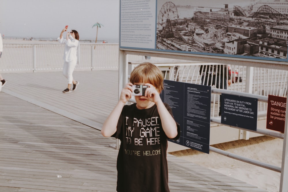 boy in black t shirt using portable camera