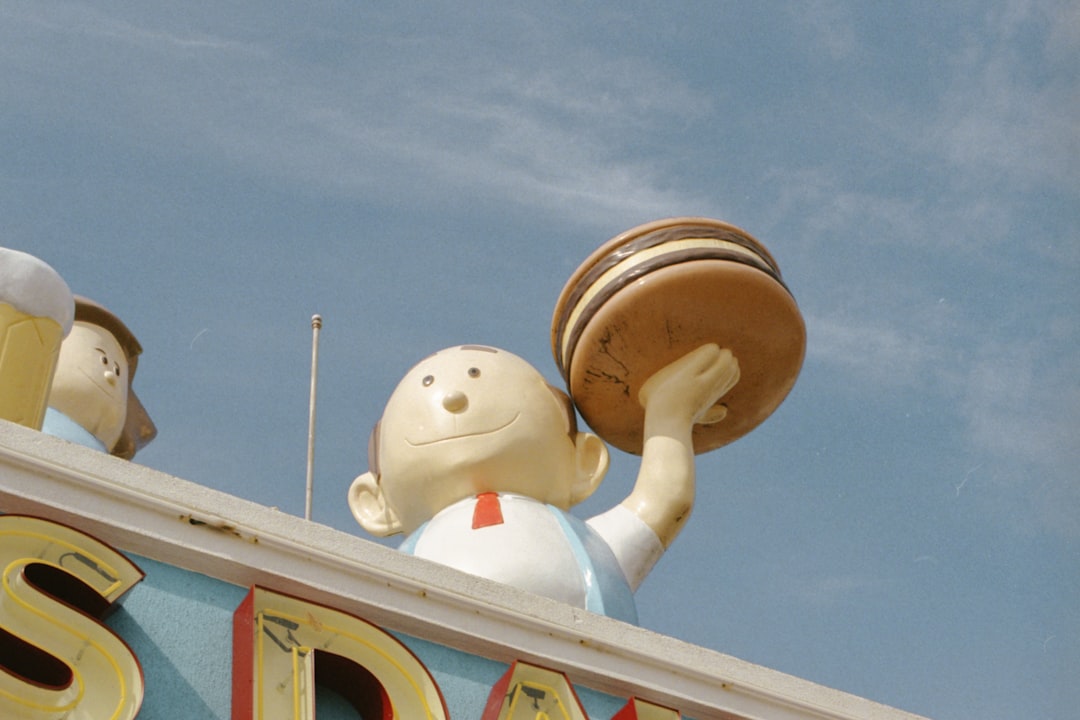 boy holding burger statue during daytime