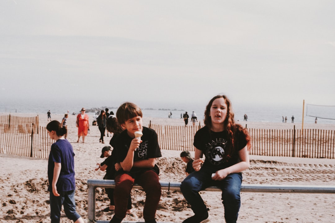 girl and boy sitting on metal rail