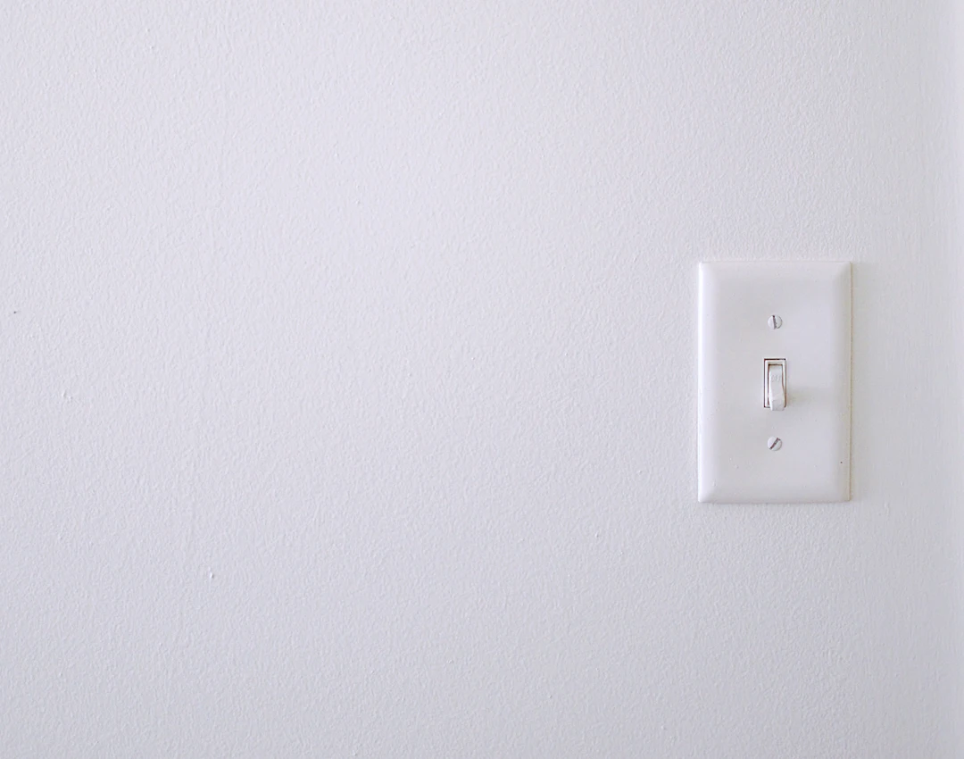 White toggle light switch on a plain white wall