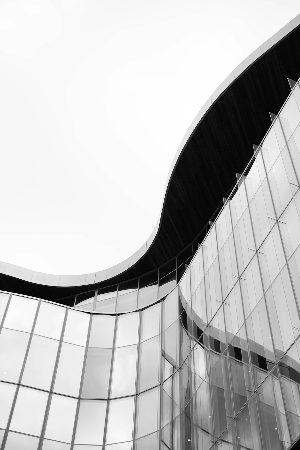 a black and white photo of a curved building