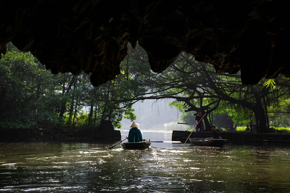 personne assise sur un bateau entouré d’arbres