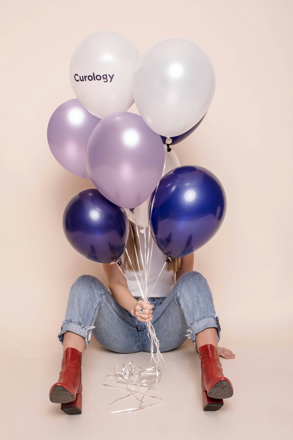 woman holding six assorted-color balloons