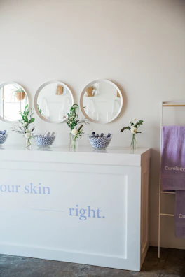 Bright and airy spa boutique interior with minimalist decor and delicate floral accents.