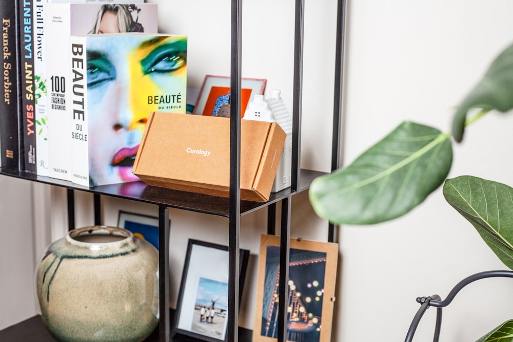 a bookshelf filled with books next to a potted plant