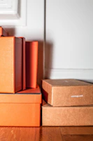 Stacked boxes of family care products tied with warm gold twine against a beige backdrop.