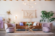 brown leather sofa and two pink sofa chair