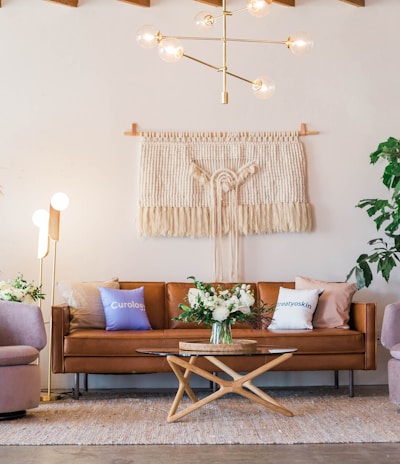 brown leather sofa and two pink sofa chair