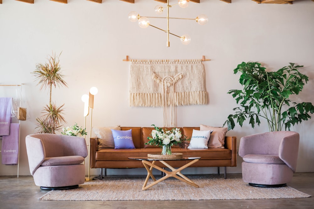 brown leather sofa and two pink sofa chair