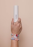 a person holding a white tube in their hand