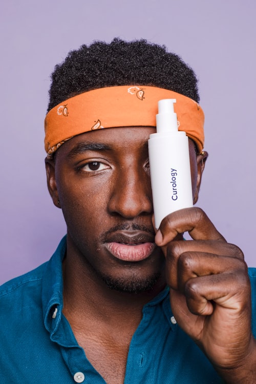 Person holding a white skincare tube