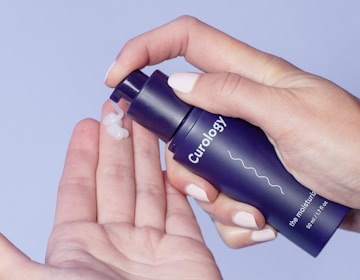 person holding Curology spray bottle