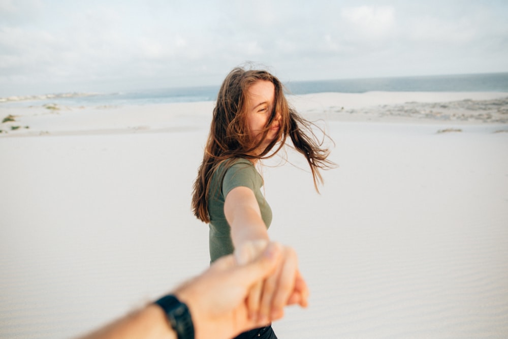 woman holding hand of person while holding camera